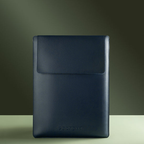 Blue laptop sleeve with SERPENT logo against a green background